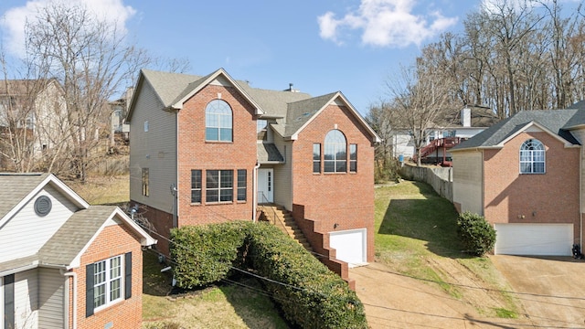 traditional-style house featuring a garage, driveway, a front yard, and brick siding