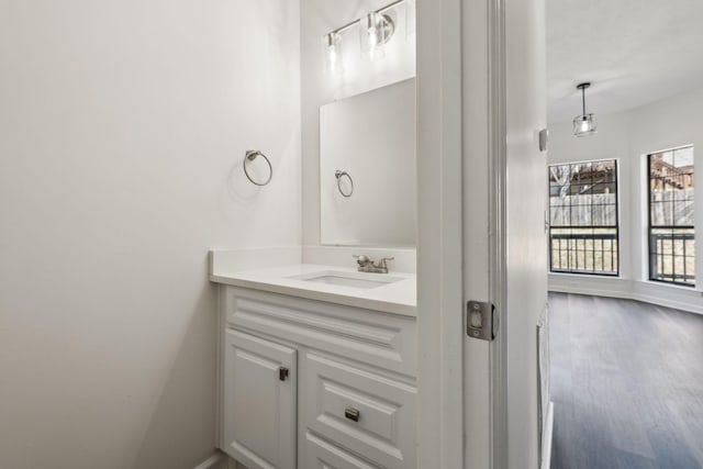 bathroom with baseboards, wood finished floors, and vanity