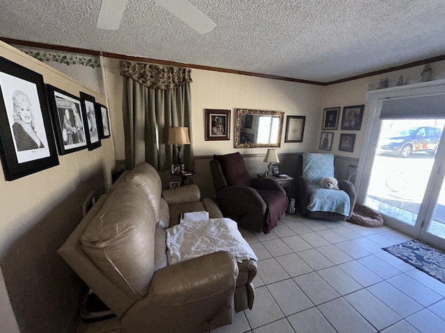 living room with light tile patterned floors, ceiling fan, ornamental molding, and a textured ceiling