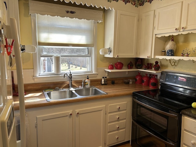 kitchen featuring a sink, white cabinets, and double oven range