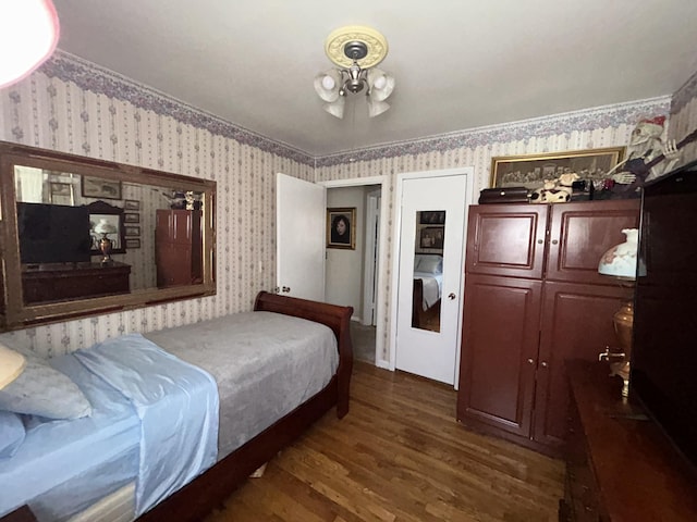 bedroom featuring dark wood-type flooring and wallpapered walls