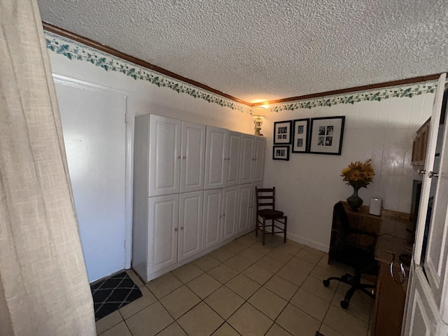 unfurnished office with crown molding, a textured ceiling, and light tile patterned floors