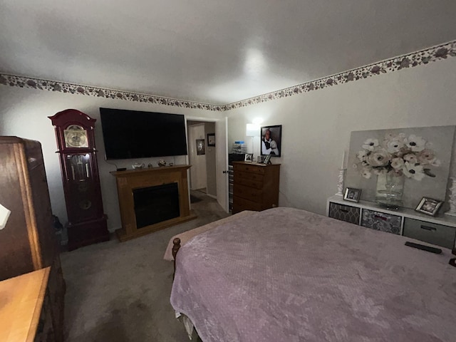 bedroom with carpet and a fireplace