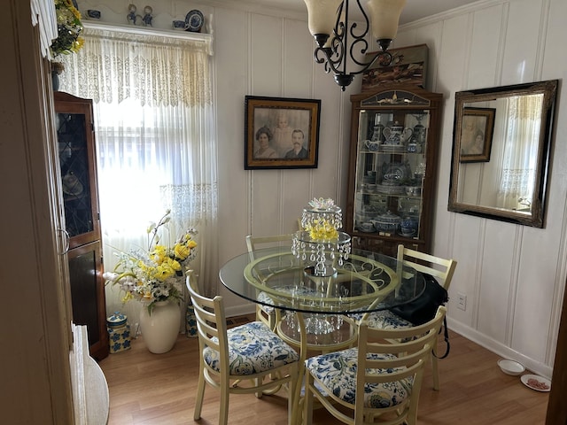 dining area featuring light wood finished floors and a decorative wall