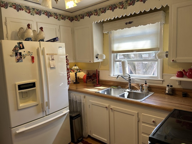 kitchen with butcher block counters, a sink, white cabinetry, black electric range oven, and white fridge with ice dispenser