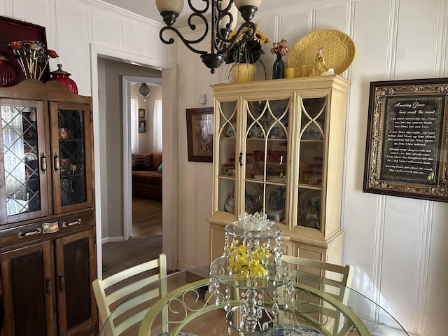 dining area featuring an inviting chandelier and a decorative wall