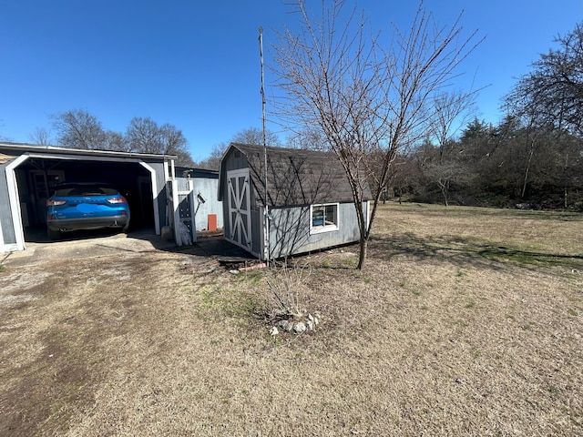 view of side of property with an outbuilding, driveway, and a storage shed