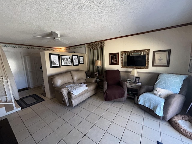 living area with ceiling fan, a textured ceiling, light tile patterned flooring, and crown molding