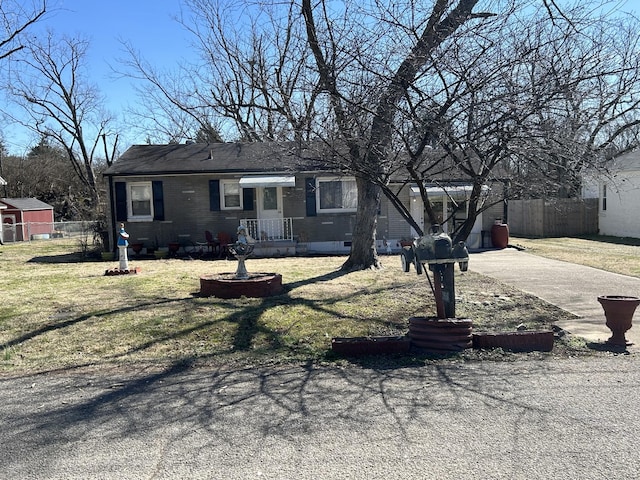 single story home with driveway, a front yard, and fence