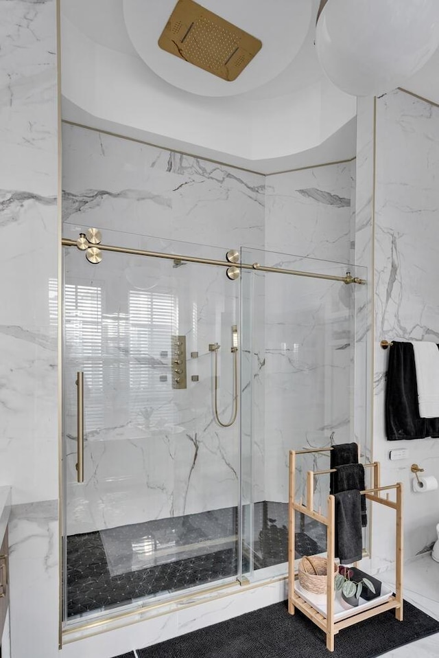 bathroom with a marble finish shower and stone wall