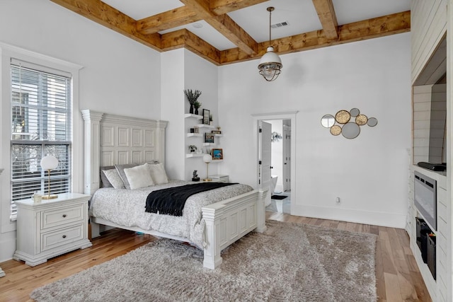 bedroom featuring baseboards, visible vents, coffered ceiling, light wood-style flooring, and beam ceiling