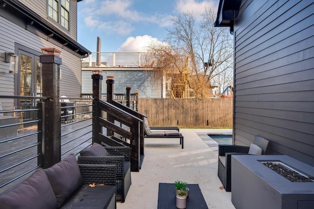 view of patio featuring an outdoor fire pit and fence