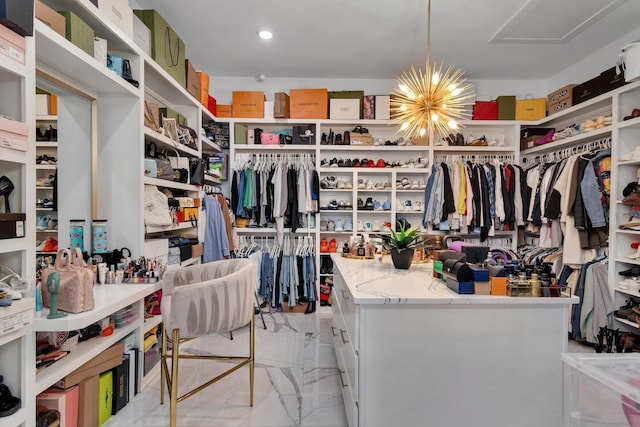 spacious closet featuring marble finish floor and an inviting chandelier