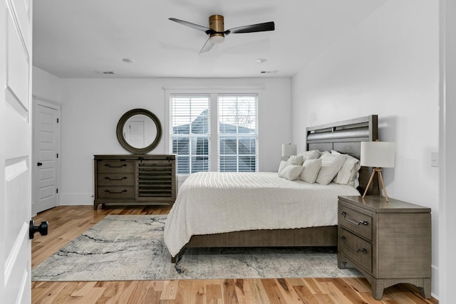 bedroom featuring light wood-style floors, ceiling fan, and visible vents