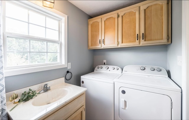 laundry room with separate washer and dryer, a sink, and cabinet space