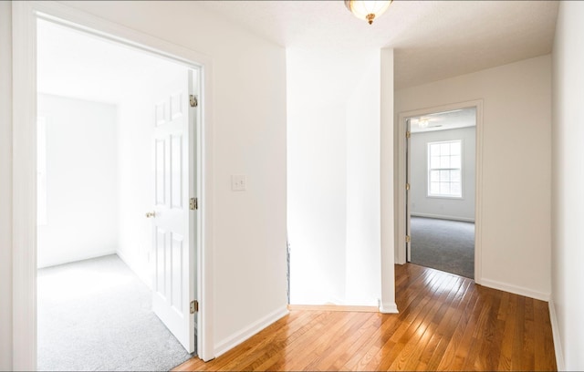 hall featuring light wood-style floors and baseboards