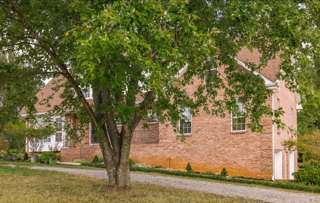 view of side of property with a yard and brick siding