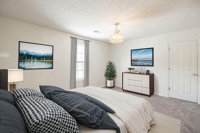 carpeted bedroom with a textured ceiling, a notable chandelier, visible vents, and baseboards