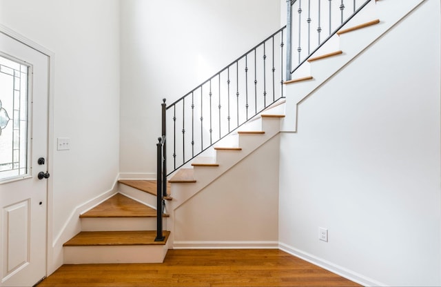 entrance foyer with stairway, wood finished floors, and baseboards