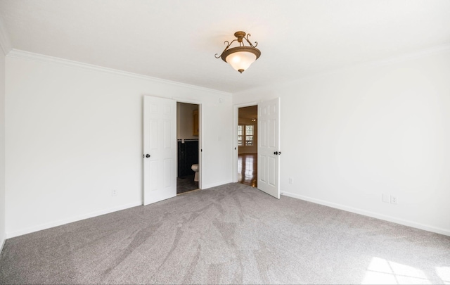 empty room with carpet floors, baseboards, and crown molding