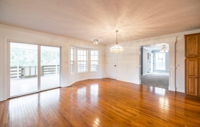 unfurnished room featuring a healthy amount of sunlight, light wood finished floors, and crown molding