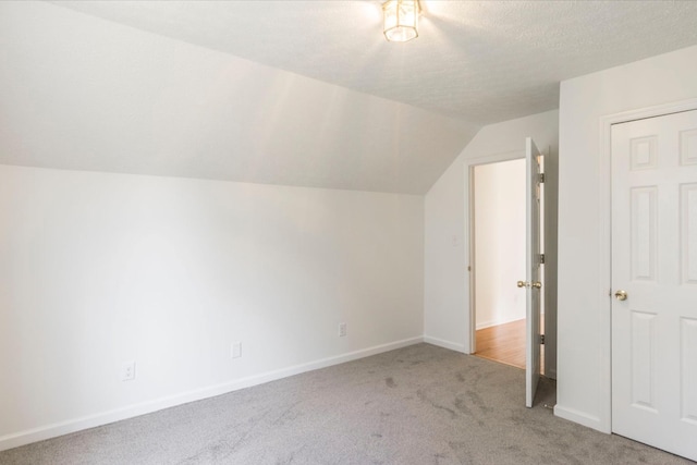 bonus room featuring carpet floors, lofted ceiling, a textured ceiling, and baseboards