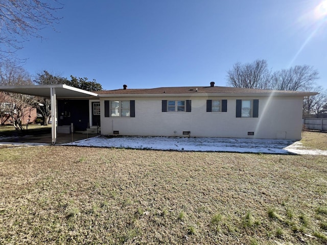 back of property with brick siding, a lawn, crawl space, a patio area, and an attached carport