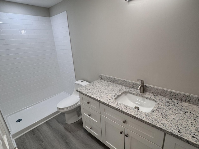 full bathroom with toilet, a stall shower, wood finished floors, and vanity