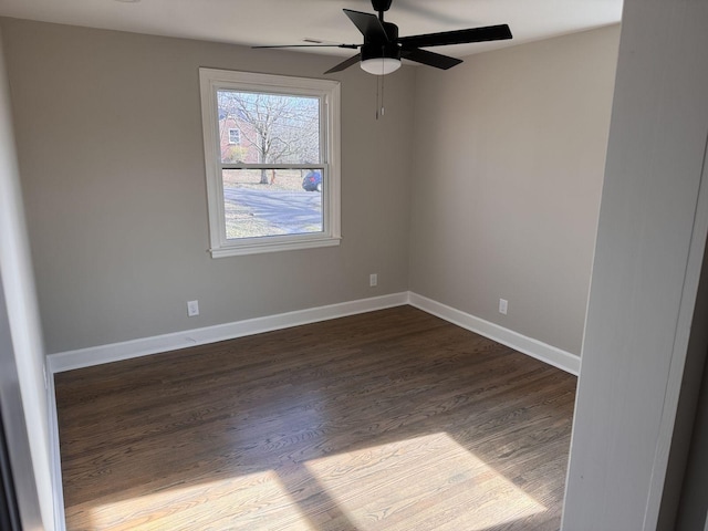 empty room featuring ceiling fan, baseboards, and dark wood-type flooring