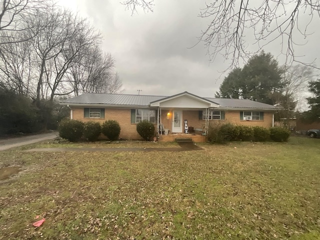 ranch-style home with covered porch, brick siding, and a front lawn