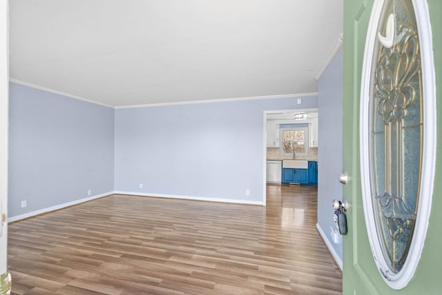 entrance foyer with ornamental molding, wood finished floors, and baseboards