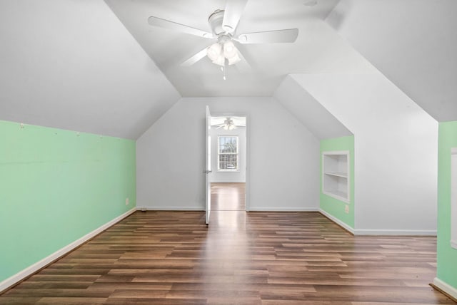 bonus room featuring built in shelves, lofted ceiling, baseboards, and wood finished floors