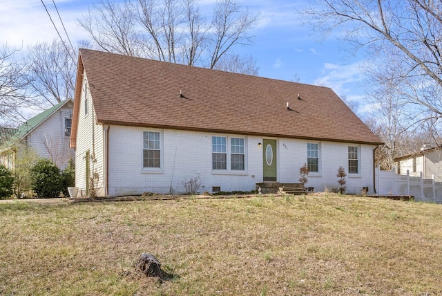 view of front of property with brick siding, a shingled roof, a front yard, crawl space, and fence