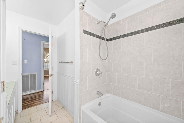 full bathroom featuring wainscoting, visible vents, bathing tub / shower combination, and tile patterned floors