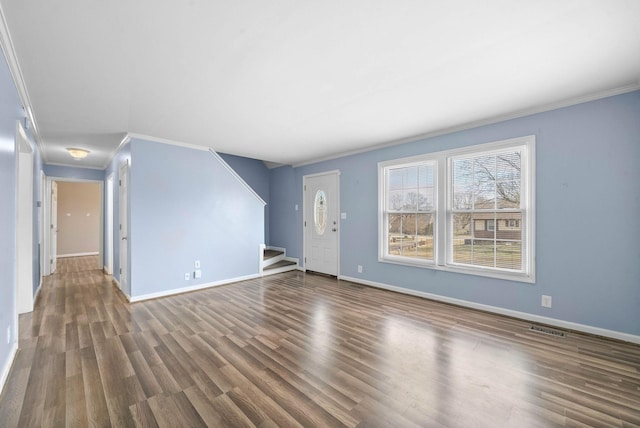 unfurnished living room with visible vents, ornamental molding, wood finished floors, baseboards, and stairs