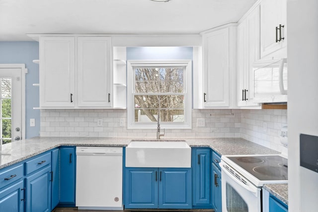 kitchen featuring white appliances, white cabinets, blue cabinetry, open shelves, and a sink