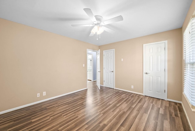 empty room featuring ceiling fan, baseboards, and wood finished floors