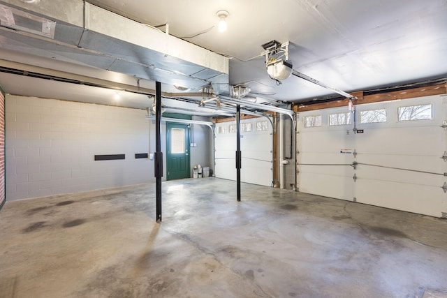 garage with concrete block wall and a garage door opener