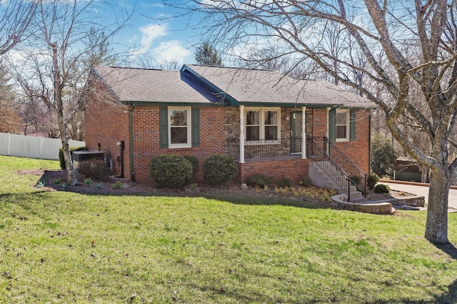 ranch-style house with fence, a front lawn, central AC, and brick siding