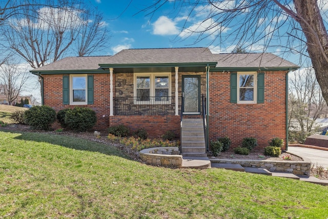 view of front of home featuring a front yard, covered porch, brick siding, and roof with shingles