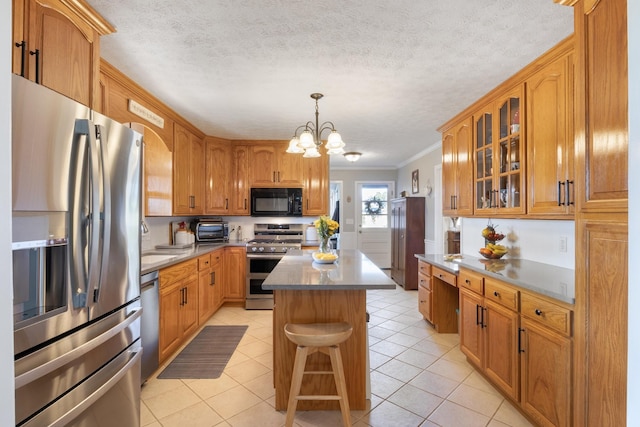 kitchen featuring crown molding, light tile patterned floors, stainless steel appliances, glass insert cabinets, and a kitchen island