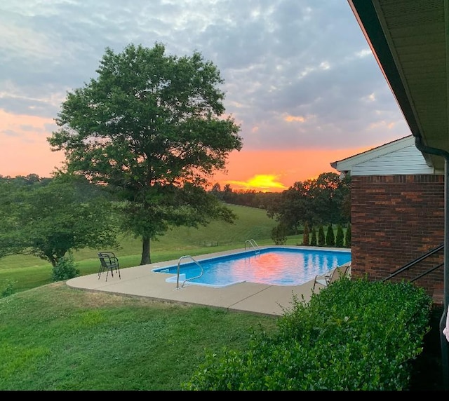 outdoor pool featuring a patio and a lawn