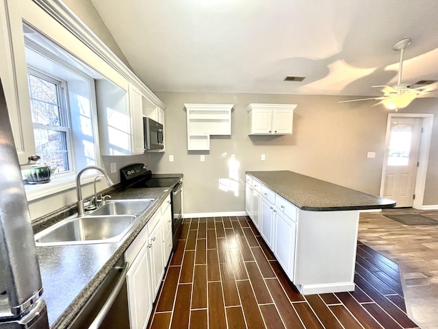 kitchen featuring electric range, wood finish floors, dark countertops, and a sink