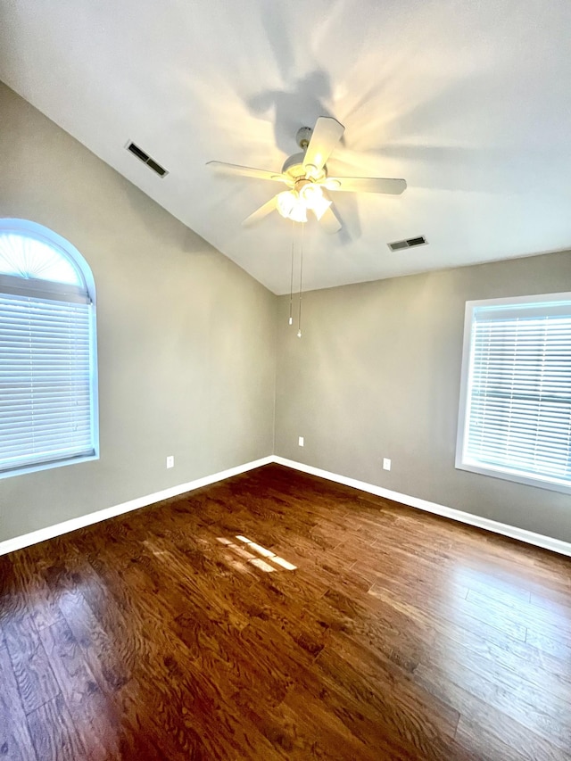 unfurnished room featuring wood finished floors, visible vents, and baseboards