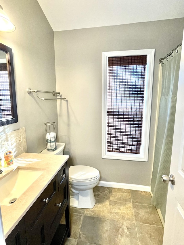 full bath featuring vanity, toilet, and baseboards