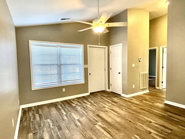 interior space with visible vents, vaulted ceiling, and wood finished floors