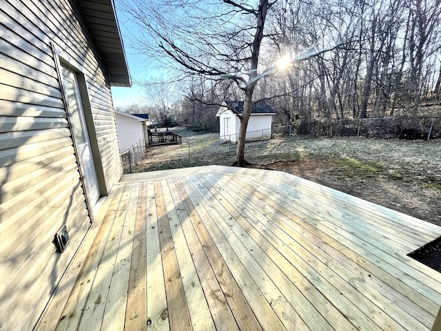 wooden deck with a shed, an outdoor structure, and a fenced backyard