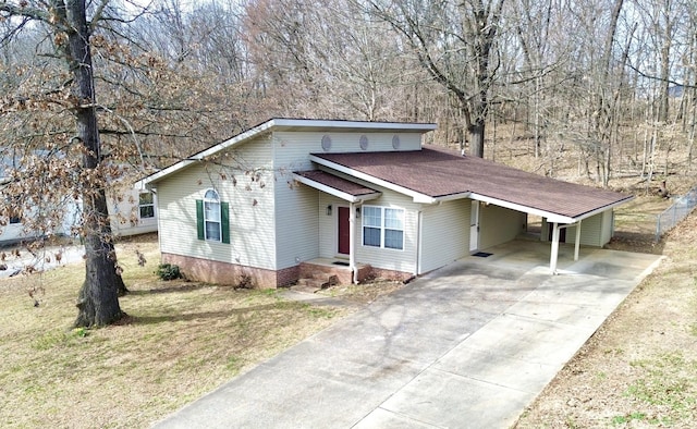 view of front facade with a carport, driveway, a front lawn, and fence