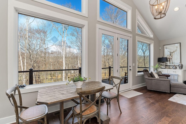 sunroom / solarium featuring a chandelier and lofted ceiling