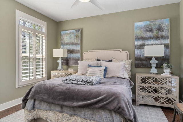 bedroom with ceiling fan, wood finished floors, and baseboards